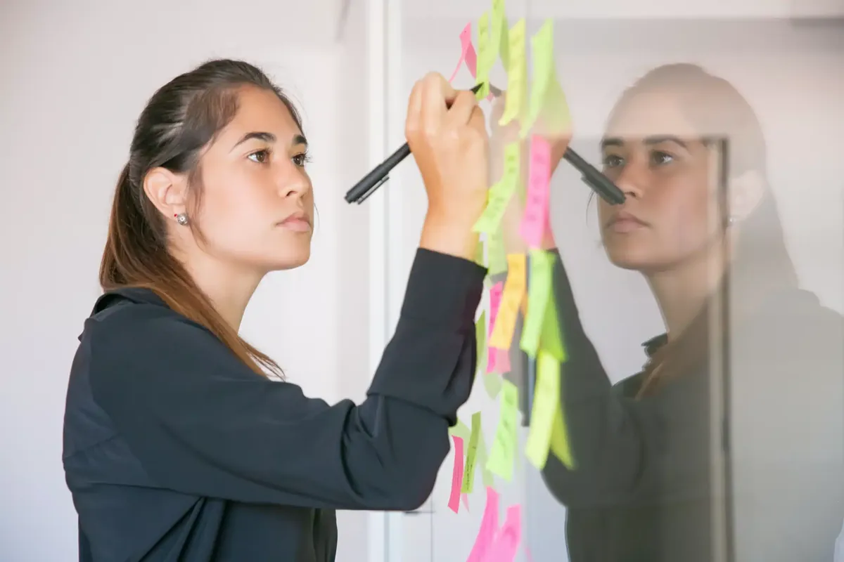 Mujer planificando los objetivos de una campaña con notas adhesivas